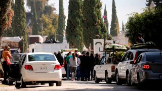 Decenas de personas y vehículos a las afueras de un cementerio en Guadalajara
