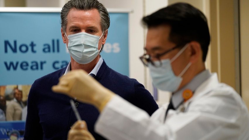 File Image: Gov. Gavin Newsom watches as the Pfizer-BioNTech COVID-19 vaccine is prepared by Director of Inpatient Pharmacy David Cheng at Kaiser Permanente Los Angeles Medical Center on December 14, 2020 in Los Angeles, California. The first doses of the vaccine are being administered to frontline workers in hospitals across the country today. (Photo by Jae C. Hong-Pool/Getty Images)