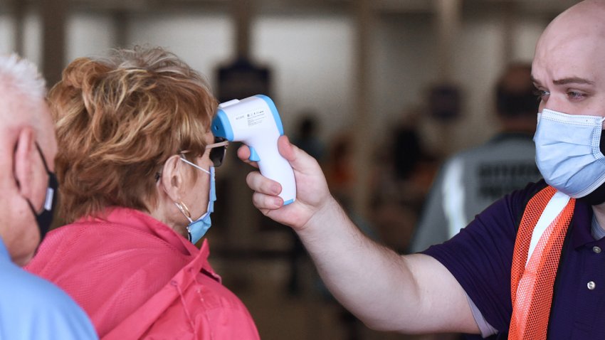 In this Jan. 29, 2021, file photo, people have their temperatures checked as they enter a walk-in COVID-19 vaccination POD inside a vacant Sears store at the Lake Square Mall.