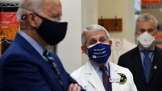 White House Chief Medical Adviser on Covid-19 Dr. Anthony Fauci (C) looks on as US President Joe Biden (L) tours the Viral Pathogenesis Laboratory at the National Institutes of Health (NIH) in Bethesda, Maryland, February 11, 2021.