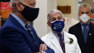 White House Chief Medical Adviser on Covid-19 Dr. Anthony Fauci (C) looks on as US President Joe Biden (L) tours the Viral Pathogenesis Laboratory at the National Institutes of Health (NIH) in Bethesda, Maryland, February 11, 2021.