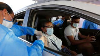 Enfermera vacuna a mujer adulta en su automóvil, en Tonalá, Jalisco
