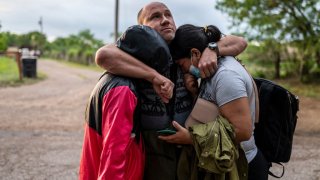 Una familia migrante se abraza tras cruzar la frontera en el sur de Estados Unidos, la semana pasada.