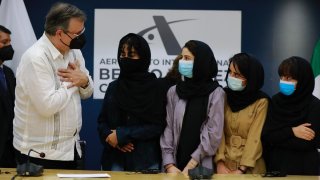 Un funcionario mexicano saluda a cuatro mujeres afganas, de las cinco, que obtuvieron refugio en México