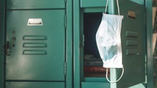 Mask hangs off a school locker