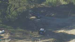Officers pursue a stolen SUV on a dirt road.