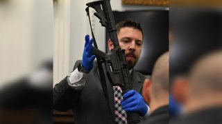 Oficial muestra evidencia de un rifle de asalto