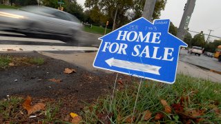 An automobile drives past a sign advertising a home for sale in Philadelphia, Pennsylvania, Wednesday, Oct. 24, 2007 (Address blurred to protect privacy).