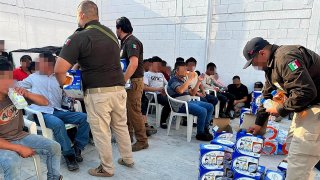 Fotografía cedida hoy por el Instituto Nacional de Migración (INM) donde se observa a personal de la dependencia regalando bebidas hidratantes a migrantes en Ciudad de México (México).