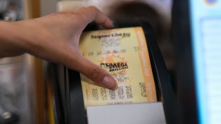 A cashier prints out a Mega Millions lottery ticket.