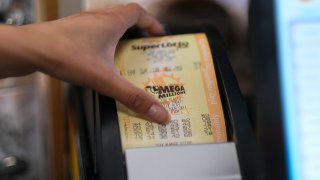 A cashier prints out a Mega Millions lottery ticket.
