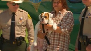 Bubba the dog and owner Mike Sentonil are pictured alongside LA County Sheriff Alex Villanueva.