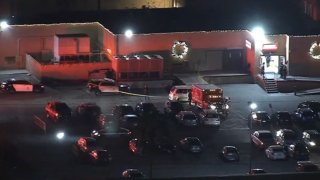 Authorities at the scene of a fatal shooting Monday night in a San Fernando Valley department store parking lot.