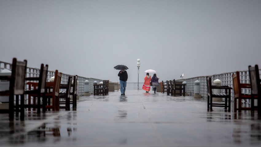 People brave the elements along the Hermosa Beach Pier.