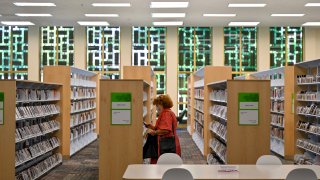 Noemi Mayorga checks out the DVDs at the L.A. County Library in Norwalk.