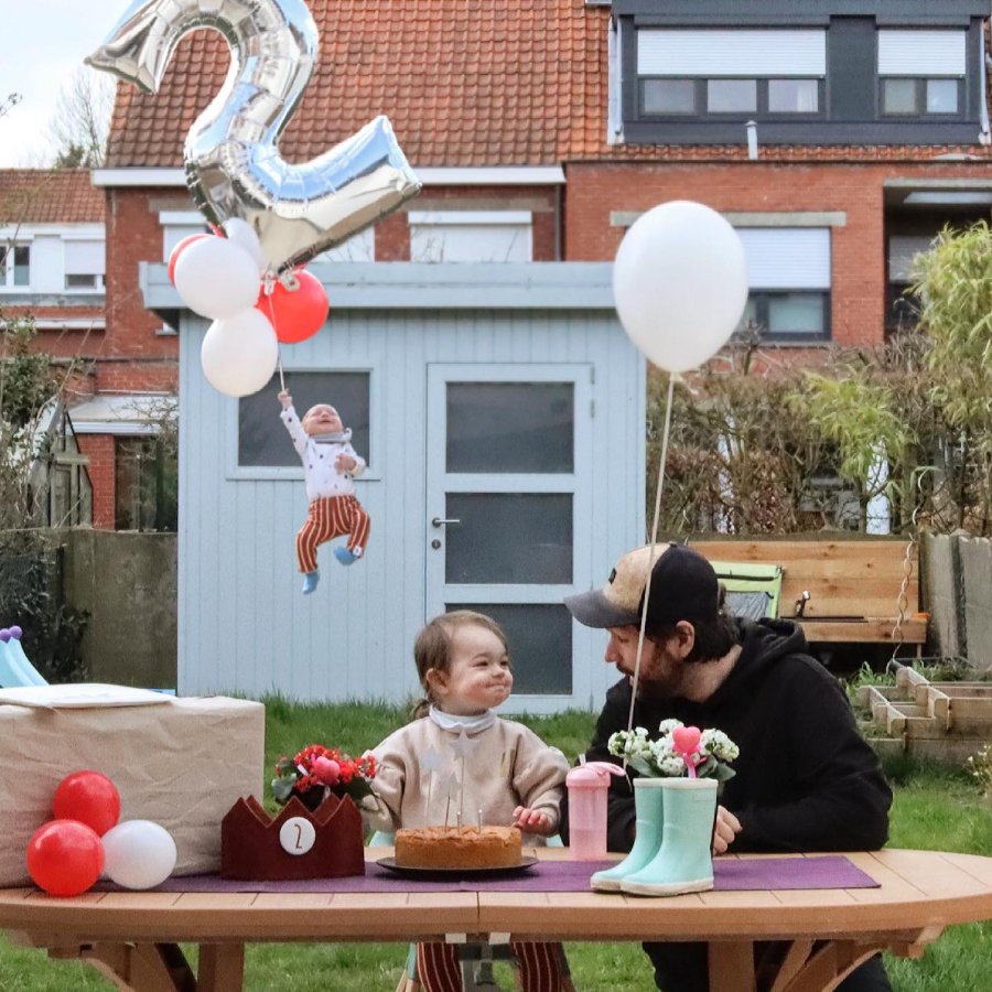 A photoshopped image of Aster celebrating her second birthday with her dad. Her baby sister floats away on a balloon in the background.