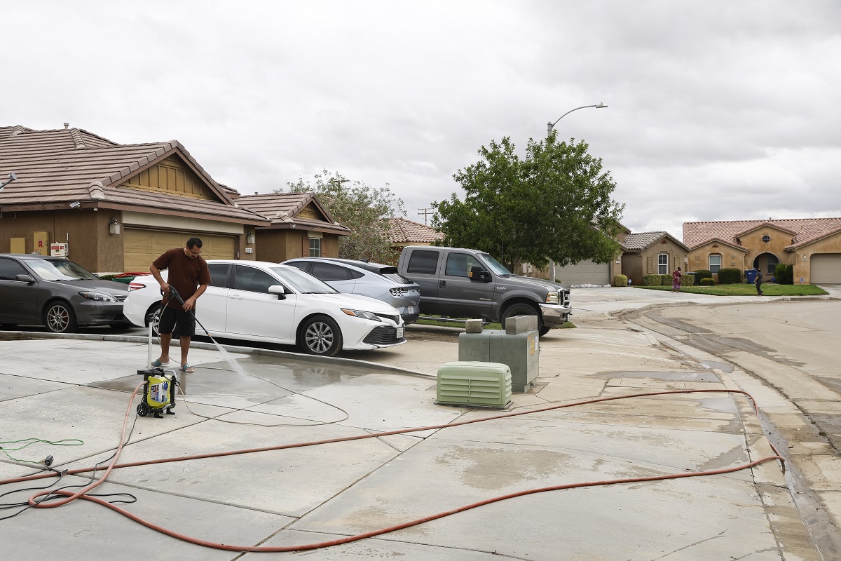 Una persona lava a máquina la suciedad que quedó de la inundación de la noche anterior en Lancaster, California, EE. UU. EFE/EPA/CAROLINE BREHMAN