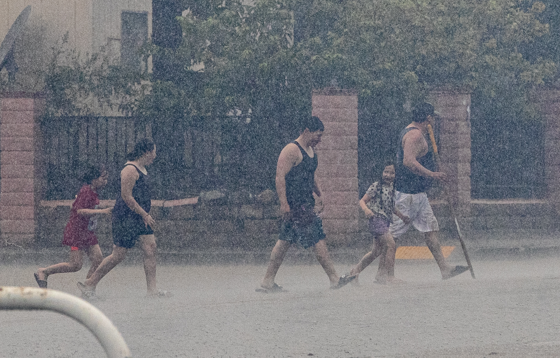 Residentes de Thermal cruzan la avenida 70 mientras la tormenta tropical Hilary arroja lluvias torrenciales en el área el 20 de agosto de 2023. (Gina Ferazzi / Los Angeles Times via Getty Images)