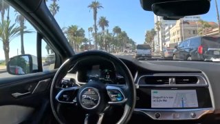 A driverless Waymo vehicle makes its way through streets in Southern California.