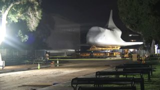 Space Shuttle Endeavour appears in protective wrapping during its move at the California Science Center Friday Jan. 26, 2024.