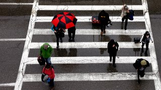 Travelers arrive at LAX in the rain.