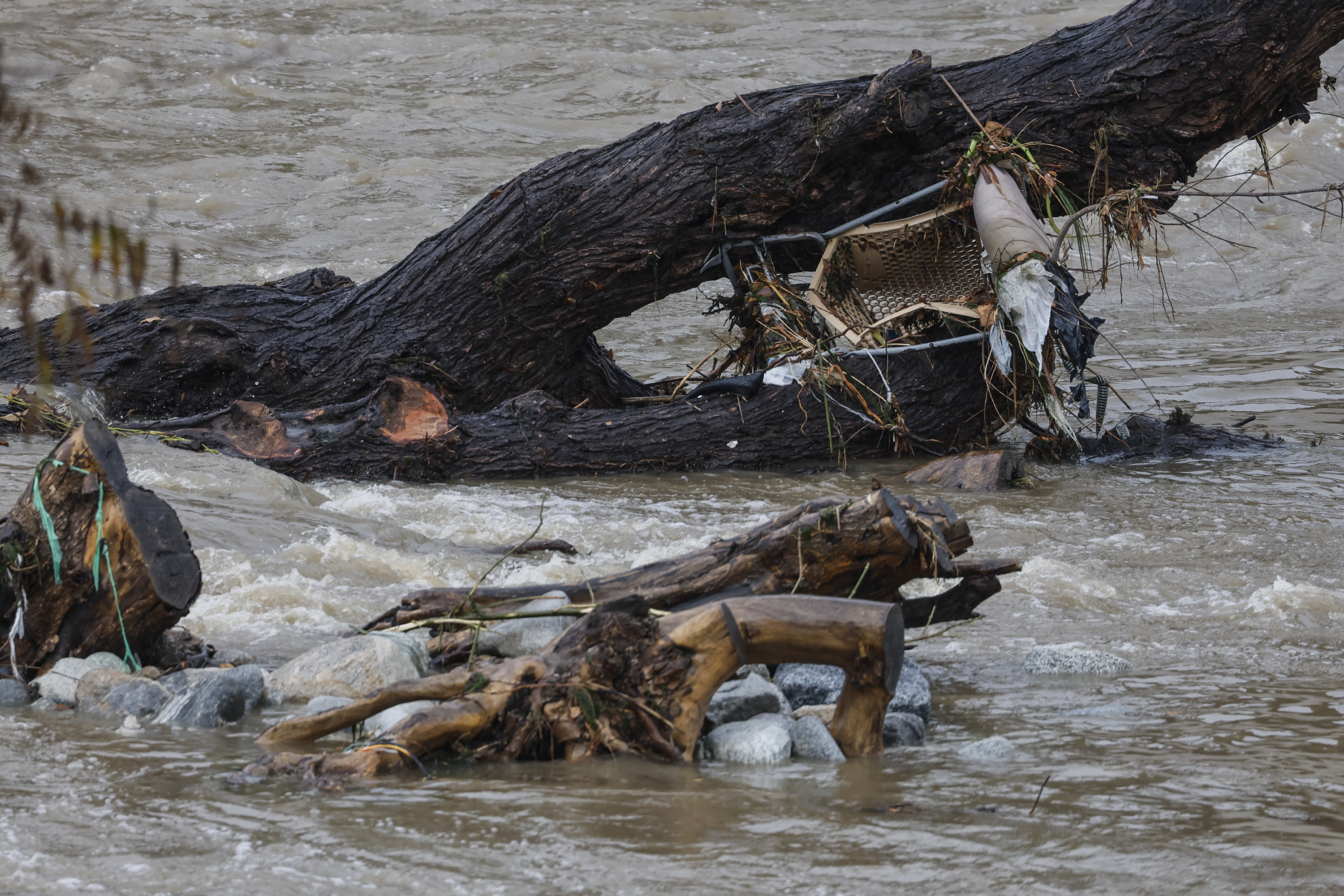 El agua de las fuertes lluvias corre por el río Los Ángeles, arrastrando consigo escombros como este carrito de compras. (Robert Gauthier/Los Angeles Times vía Getty Images)