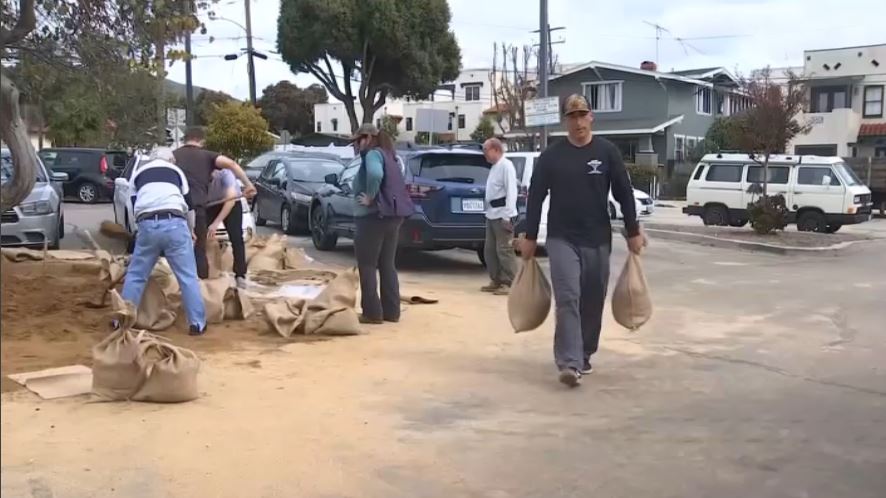 Residentes llenan sacos de arena antes de una tormenta en Ventura