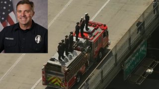 Colleagues salute from a freeway overpass as a procession passes June 19, 2024 for LA Andrew Pontious.