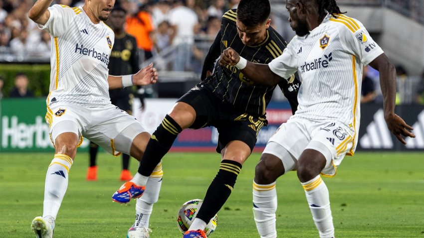 Joseph Paintsil (d) de los Ángeles Galaxy disputa el balón con Eduard Atuesta (c) de Los Ángeles FC, este jueves durante un partido de la Mayor League Soccer (MLS) en el estadio Rose Bowl Stadium, en Pasadena (EWstados Unidos). EFE/ Armando Arorizo