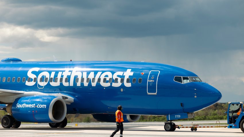 La mitad delantera de un avión que dice "Southwest" y un hombre al frente.