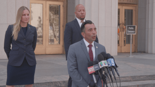 US Attorney Martin Estrada, at microphones, announced a federal indictment Monday that accused 2 former LA County Sheriff's deputies of taking part in a false immigration raid aimed at extorting a man out of millions of dollars.