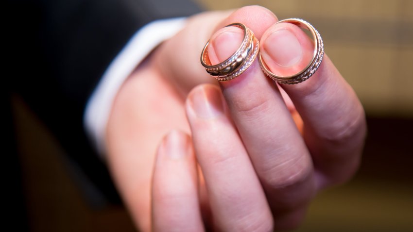 Gold wedding rings in the man’s hand. Close up.