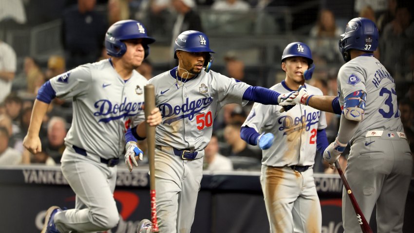 BRONX, NEW YORK – OCTOBER 30, 2024: Teammates congratulates Los Angeles Dodgers shortstop Mookie Betts (50), center, after he hits a sacrifice fly for Will Smith to score in the eighth inning. Game 5 of the World Series against the Yankees at Yankees Stadium in New York City Wednesday, October 30 2024. (Robert Gauthier/Los Angeles Times via Getty Images)