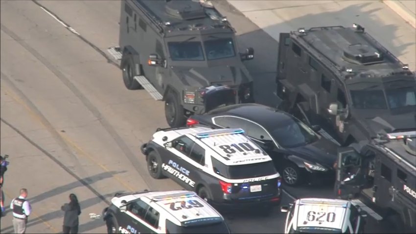 A black sedan is surrounded by police cruisers and armored vehicles during a standoff in El Segundo on Tuesday, Oct. 15, 2024.