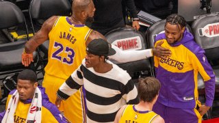 LeBron James de los Ángeles Lakers saluda a su hijo Bronny James durante un partido de la NBA en Toronto (Canadá). EFE/Julio César Rivas