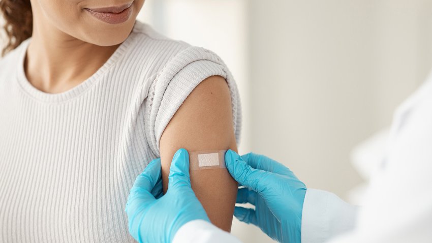 Vaccine, happy woman and hands of doctor with plaster for health, wellness and service in clinic. Healthcare, patient and expert in hospital for immune system strength, illness prevention or flu shot