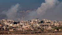 Esta imagen tomada desde el lado israelí de la frontera con la Franja de Gaza muestra columnas de humo detrás de edificios destruidos en el norte de la Franja de Gaza el 13 de enero de 2025, en medio de la guerra en curso entre Israel y Hamás.