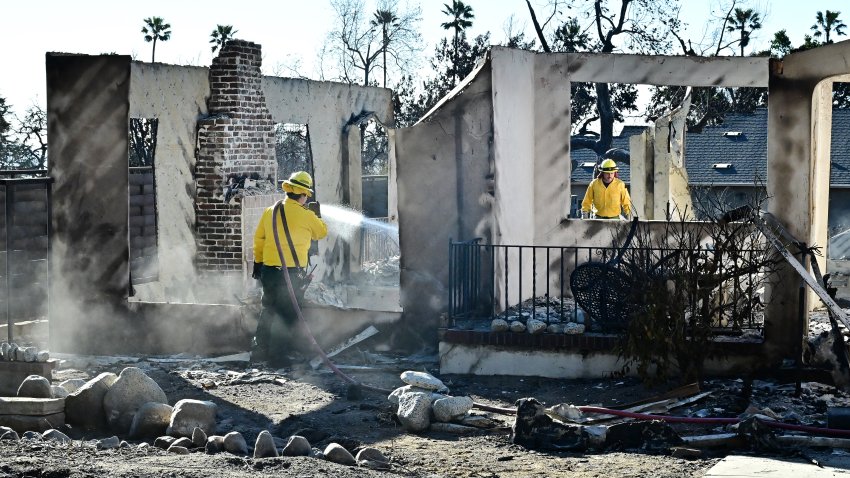 Firefighters spray the rubble of fire-avaged homes in Altadena, California on January 15, 2025, that were demolished by the Eaton Fire.