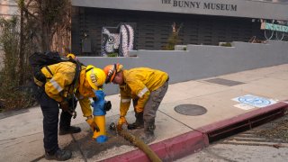 Bomberos trabajan en un hidrante frente al Bunny Museum en llamas, el miércoles 8 de enero de 2025, en la sección Altadena de Pasadena, California.