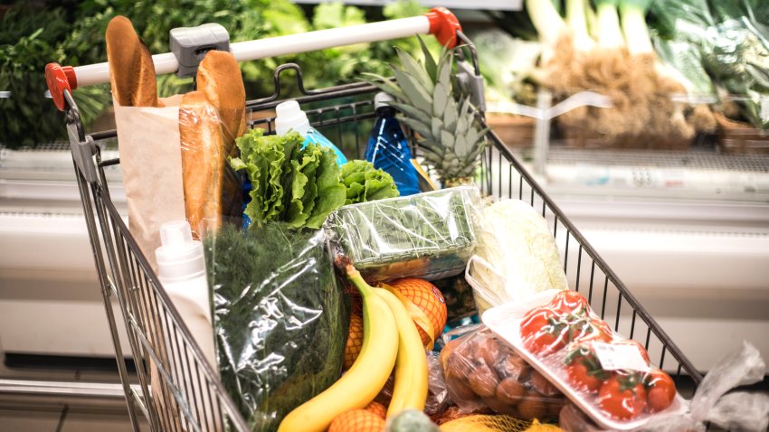 Full of products shopping grocery cart in supermarket.