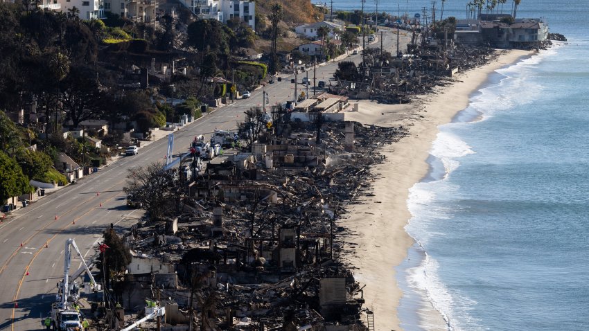 LOS ANGELES, CALIFORNIA – JANUARY 12: Vehicles run on the Palisades section of Pacific Coast Highway along scorched structures and trees by wildfires on January 12, 2025 in Los Angeles, California. The Palisades and Eaton fires have forced tens of thousands of residents to flee this week, leaving many wondering what may remain of their homes in Pacific Palisades, Altadena and surrounding areas. (Photo by Qian Weizhong/VCG via Getty Images)