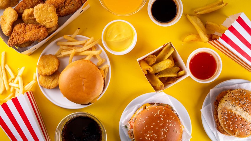 Fast food delivery menu background with various burgers, cheeseburger, nuggets, french fries, fizzy soda drinks. Junk unhealthy fast food, Ultra processed food with low nutrition, high calories value