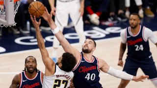 El escolta de los Denver Nuggets Jamal Murray (I), avanza hacia la canasta con la pelota mientras es defendido por el pívot de Los Angeles Clippers, Ivica Zubac (D), durante la segunda mitad del partido de playoffs de primera ronda entre los Denver Nuggets y Los Angeles Clippers en Inglewood, California, EE. UU. EFE/EPA/CAROLINE BREHMAN
