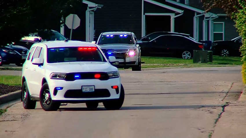 Police cars with lights flashing parked on street
