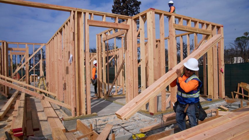 Workers rebuild a property destroyed by the Palisades Fire in the Pacific Palisades neighborhood of Los Angeles, Thursday, April 24, 2025. (AP Photo/Damian Dovarganes)