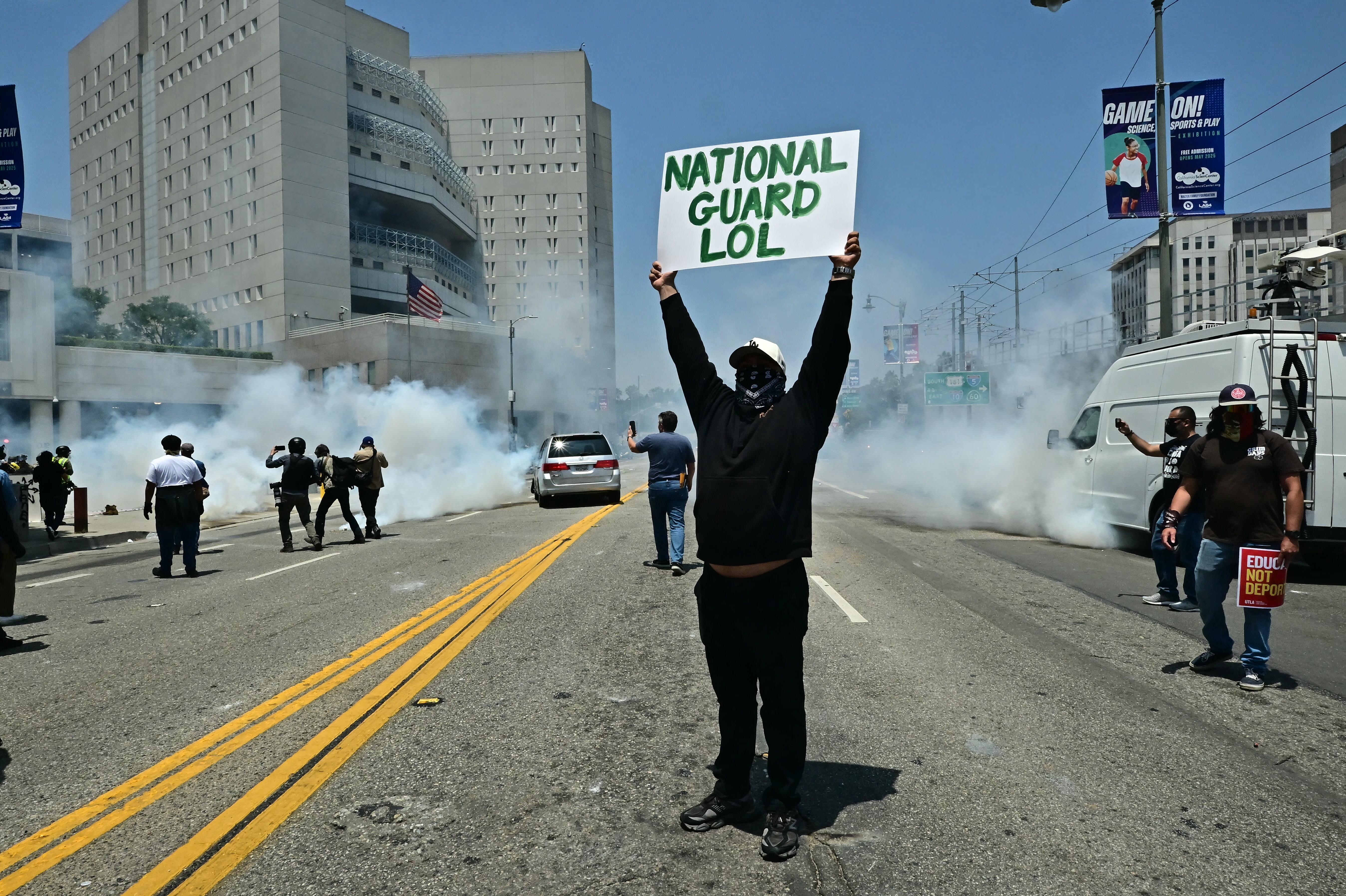 Se observa a manifestantes entre el humo durante un enfrentamiento con soldados de la Guardia Nacional y agentes de policía del Departamento de Seguridad Nacional (DHS) de EE. UU. frente al Centro de Detención Metropolitano (MDC), en el centro de Los Ángeles, California, el 8 de junio de 2025.