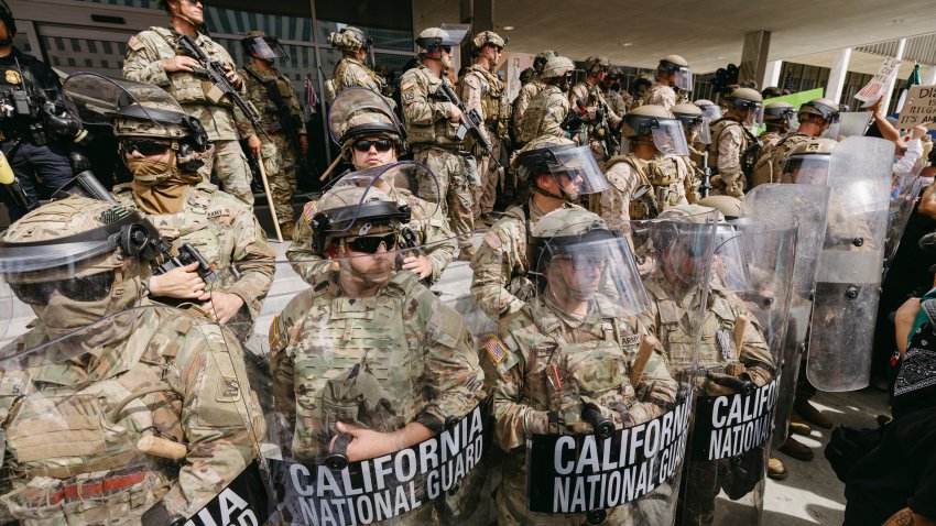 California National Guard members stand in formation during the protest in Los Angeles, California on June 14, 2025. Masses of demonstrators filled streets, parks, and plazas across the United States to protest President Donald Trump. Organized as part of the nationwide “No Kings” movement, the protests featured over 2,000 coordinated demonstrations with participation from more than five million people. In cities and small towns alike, protesters marched with anti-authoritarian chants, demanding the protection of democracy and immigrant rights. (Photo by David Pashaee / Middle East Images via AFP) (Photo by DAVID PASHAEE/Middle East Images/AFP via Getty Images)