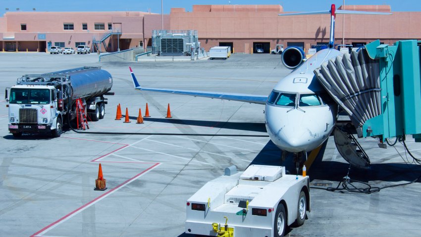 An aircraft being refuelled at Albuquerque International Sunport airport in Albuquerque, New Mexico. A jet bridge or airbridge (used to transfer passengers from a boarding gate to an aircraft) can be seen at right.