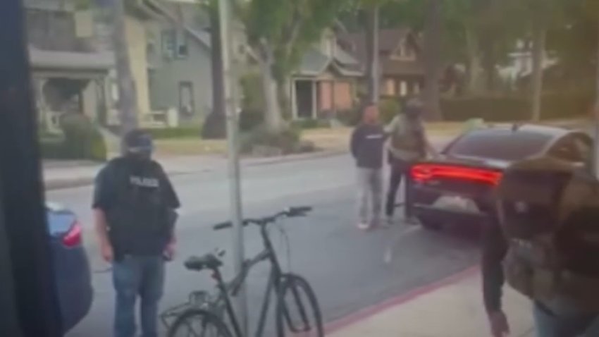 Federal agents detain an individual during an immigration raid in Pasadena on Wednesday, June 18, 2025.