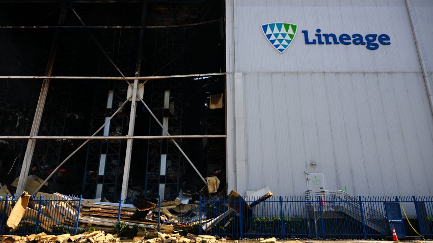 Burned debris are seen as firefighters continue fighting the Lineage cold storage warehouse fire in the Boyle Heights neighborhood of Los Angeles, California, on June 23, 2026. Los Angeles is under a state of emergency after the fire broke out on June 17 in a 500,000-square-foot frozen food warehouse, where burning foam insulation, suspected ammonia leakage and melting solar panels have complicated the firefight, officials said. (Photo by Patrick T. Fallon / AFP via Getty Images)